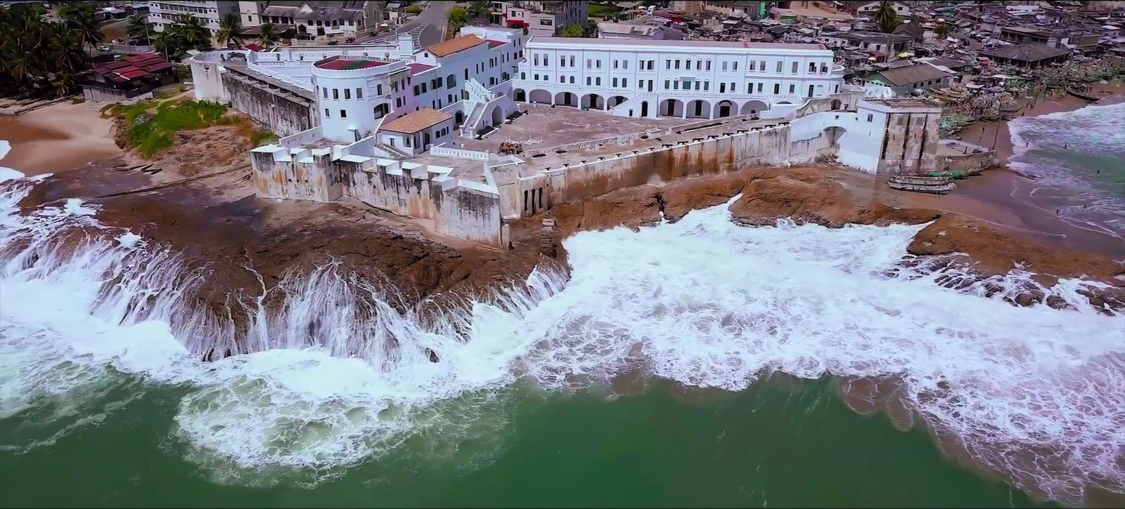 Aerial view of Cape Coast Castle with the Atlantic surf breaking on the rocks